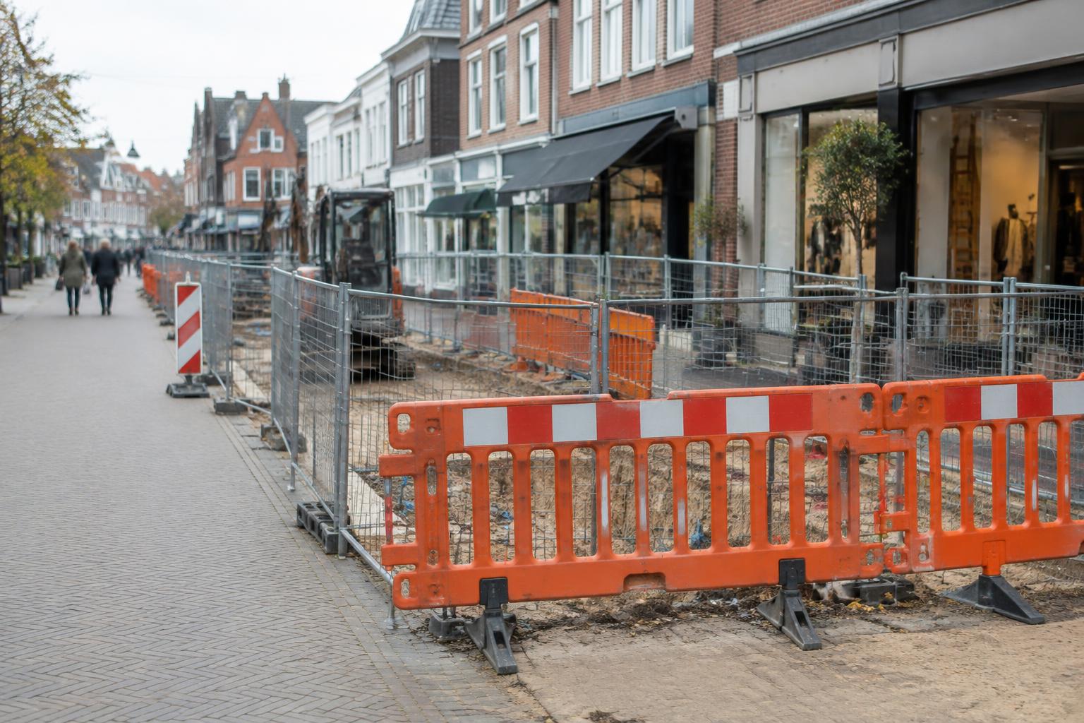 Wegwerkzaamheden met afzettingen voor winkels in een winkelstraat